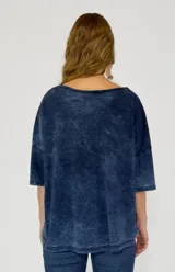 Remera de algodón con efecto lavado, color naranja, de corte oversize, cuello redondo y mangas cortas. Presenta una abertura lateral con botones decorativos.