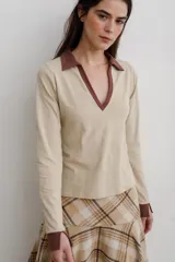 Remera de algodón con cuello camisero y escote en V profundo, de manga larga con puños en contraste de color.