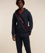 Pantalón deportivo de corte jogger, color negro, con cintura elástica ajustable mediante cordón, bolsillos laterales y puños acanalados en los tobillos. Confeccionado en tejido de algodón con interior felpudo.