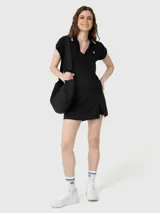 Polera manga corta negra con cuello polo y escote en V, con dos rayas blancas en el cuello y un logo blanco bordado en el pecho. Confeccionada con baño de Aloe Vera para mayor suavidad.