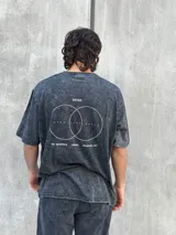 Remera gris con efecto lavado, corte oversize, manga corta y estampado pequeño en el frente.