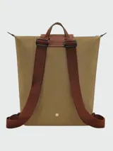 Mochila Longchamp de la línea Le Pliage Original, tamaño M, en color rosado con solapa y asas de cuero marrón.