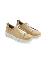Sneaker Furla de cuero color beige, con suela anatómica elevada blanca, cordones blancos y detalle de elástico fruncido en el tobillo.
