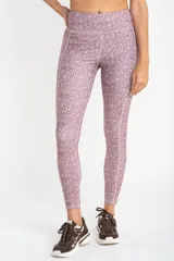 Legging deportivo de tiro alto con estampado botánico abstracto en tonos rosados y marrones, confeccionado en tejido elástico de secado rápido.