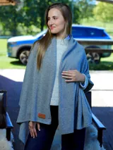 Pashmina de lana color gris, con diseño envolvente y etiqueta de cuero sintético en el borde inferior.