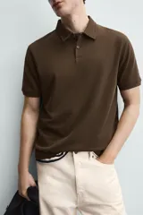 Polo de corte regular fit en tejido de algodón con estructura vertical color beige. Presenta cuello solapa, cierre frontal de botonadura y manga corta con rib.
