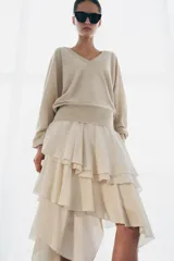 Falda midi de tiro alto, color marrón oscuro, con múltiples capas de volantes y bajo asimétrico.
