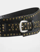 Cinturón tipo faja de cuero vegano negro, con diseño ancho y decorado con múltiples tachas metálicas doradas y ojales. Incluye una hebilla metálica plateada.