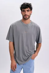Remera de manga corta oversize color gris claro, con cuello redondo y estampa pequeña frontal con la inscripción "Sailing Club France".