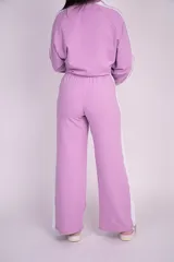 Pantalón deportivo azul de corte holgado y pierna ancha, con cintura elástica, cordón ajustable blanco y franjas laterales blancas.