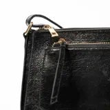 Bandolera negra con correa ajustable y bolsillo frontal con cierre.