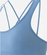 Top deportivo Get Over confeccionado en poliamida seamless, con escote redondo, breteles cruzados en la espalda y diseño sin costuras para mayor comodidad.