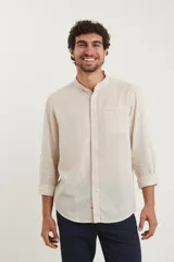 Camisa de cuello mao y manga larga, confeccionada en una mezcla de lino y algodón. Presenta un diseño de corte recto con botones en tono natural y un bolsillo pequeño en el pecho.