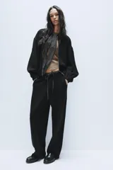 Pantalón de punto de tiro alto con bolsillos delanteros y bolsillos de plastrón en la parte trasera. Presenta una cintura doble ajustable con cordón en tejido a contraste.