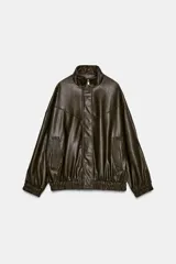 Cazadora estilo bomber color marrón oscuro, con efecto piel, cuello subido y manga larga. Tiene bolsillos delanteros con cierre de cremallera y acabados elásticos en puños y bajo. El cierre frontal es con cremallera y botones a presión ocultos.