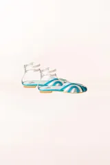 Sandalias tipo cangrejeras plateadas y celestes, con rejilla en la punta y tira al tobillo. Fabricadas en España.