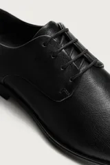 Zapato de vestir tipo derby fabricado en piel, con forro interior y plantilla de piel. Presenta horma cuadrada y suela con ligero tacón.