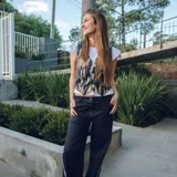 Chaleco corto con estampado abstracto en tonos dorados y azules, escote en V y cierre frontal con botones de madera.