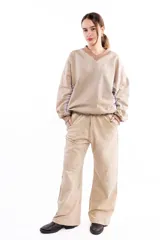 Buzo de algodón y cáñamo color beige con efecto lavado, escote en V y diseño con cortes estructurales en cuerpo y mangas. Presenta puños y cintura tejidos en tono contrastante.