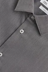 Camisa de hombre color beige claro, de corte slim fit, con cuello italiano, manga larga y cierre frontal de botonadura.