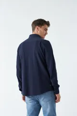 Camisa manga larga verde oliva con fit regular, mangas con botones y logo bordado.