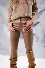 Pantalón chupín color marrón engomado y elastizado, con bolsillos traseros y presillas.