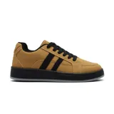 Championes deportivos de estilo urbano, color tostado con detalles en negro. Presentan un diseño de caña baja con cordones negros, suela de goma negra y franjas laterales decorativas.