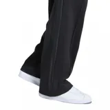 Pantalón de jogging deportivo Adidas modelo Firebird, de color negro, con cintura elástica con cordón de ajuste interno y las clásicas tiras laterales de la marca tono sobre tono. Presenta bolsillos laterales con cierre y el logo del Trifolio bordado en la pierna.