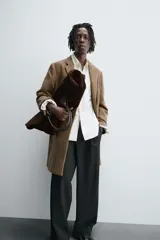 Abrigo de corte regular fit confeccionado en tejido compacto con mezcla de lana. Presenta cuello con solapas de muesca, cierre frontal de botonadura, bolsillos de vivo en la cadera y abertura central en la espalda.