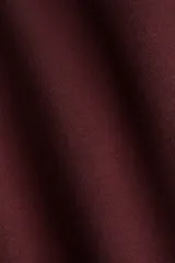 Pantalón de jogging color bordó, confeccionado en felpa con interior cepillado suave. Presenta cintura elástica con cordón ajustable y corte amplio en las piernas, con bolsillos discretos en las costuras laterales.