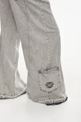 Jean de denim celeste de tiro alto y silueta wide leg, con costuras marcadas, bolsillos funcionales, bolsillo trasero inferior con bordado y terminación desflecada en el ruedo.