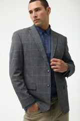 Blazer de corte sastre en color gris con estampado de cuadros en tonos azules. Presenta cierre frontal de dos botones, solapas clásicas y bolsillos laterales con solapa.