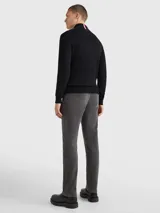 Cárdigan Tommy Hilfiger de color negro confeccionado en una mezcla de algodón pima orgánico y cachemira. Presenta un diseño con cierre de cremallera frontal, cuello levantado de punto canalé y el logo de la marca bordado en el pecho.