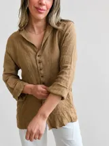 Camisa de lino gris oscuro con cuello solapa, mangas largas remangadas y cierre frontal de botones marrones.