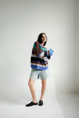 Buzo tejido con diseño de rayas horizontales en tonos marrón, azul, verde y blanco.