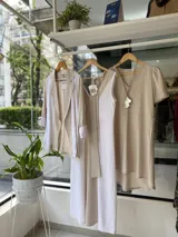 Vestido midi blanco y beige con escote en V, sin mangas y cinturón con hebilla de nácar.