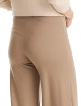 Pantalón de tiro alto con corte wide leg, confeccionado en tejido elastizado. Presenta una costura vertical decorativa en el frente de cada pierna y un diseño de calce cómodo.