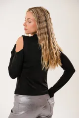 Polera negra de manga larga con diseño cut-out en hombros y pecho, confeccionada en tela elástica con acabado brillante.