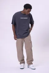 Camiseta de manga corta, color gris oscuro con efecto lavado, corte oversize y cuello redondo. Presenta un pequeño estampado en el pecho con el texto "CREW MEMBER" en blanco.