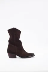 Bota corta de estilo western confeccionada en cuero descarne color marrón oscuro, con taco cuadrado de madera y punta ligeramente afinada.