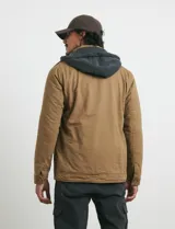 Campera de tejido técnico elástico en color verde oliva, con capucha integrada, cierre frontal y bolsillos con cierre en el pecho. Cuenta con forro interior de micro polar y diseño funcional.