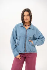 Campera de jean color celeste con silueta relajada y calce amplio. Presenta cierre frontal metálico, cuello clásico y bolsillos laterales.