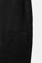 Jeans de tiro medio estilo balloon en color negro, con diseño de cinco bolsillos, trabillas para cinturón y cierre frontal con cremallera y botón metálico.