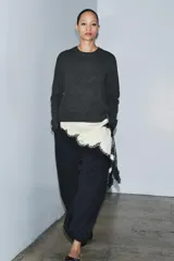Pantalón de tiro medio, color negro con rayas diplomáticas finas blancas. Cintura elástica ajustable con cordones y bajo abullonado con elástico.