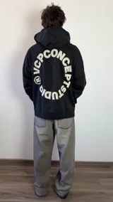 Buzo canguro oversize de algodón, color azul oscuro, con capucha y diseño gráfico circular estampado en la espalda con la inscripción VCP CONCEPTS STUDIO.