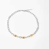 Colgante de cadena de eslabones plateados con tres dijes en forma de candado en tono dorado integrados en la estructura.