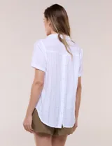 Blusa blanca de algodón texturizado con sutil relieve de rayas verticales al tono, escote en V con cuello solapa pequeño y mangas cortas.