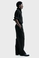 Pantalón de corte relajado con cintura elástica y cordón de ajuste. Presenta pliegues frontales y traseros, bolsillos laterales discretos y un bolsillo trasero insertado.
