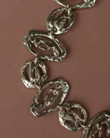 Gargantilla de diseño artesanal compuesta por eslabones de formas orgánicas y texturizadas, con cadena de ajuste posterior.