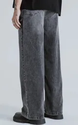 Pantalón de denim 100% algodón, color negro con lavado ácido/desgastado. Diseño de cinco bolsillos y calce wide leg.